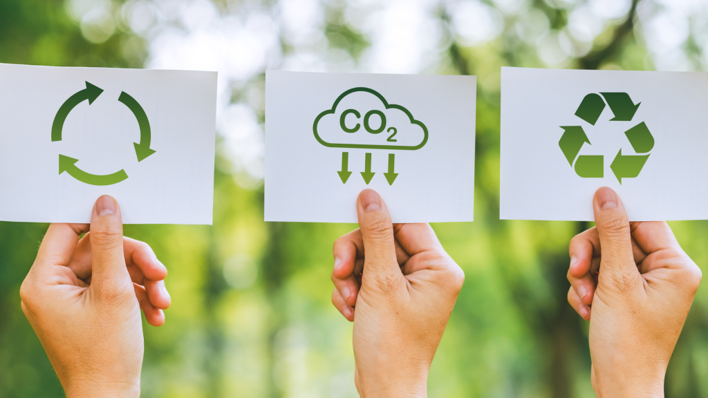 Kolme lappua, joissa on kierrättämisen ja hiilidioksidin kuvat.